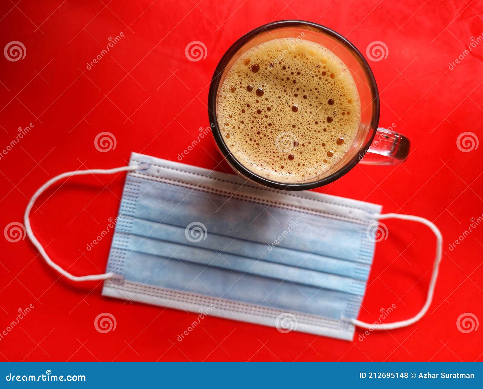 flat lay shot of teh tarik, the famous malaysian tea and sweetened, onÃÂ red background with face mask.ÃÂ 